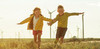 Zwei Kinder laufen über ein Rapsfeld