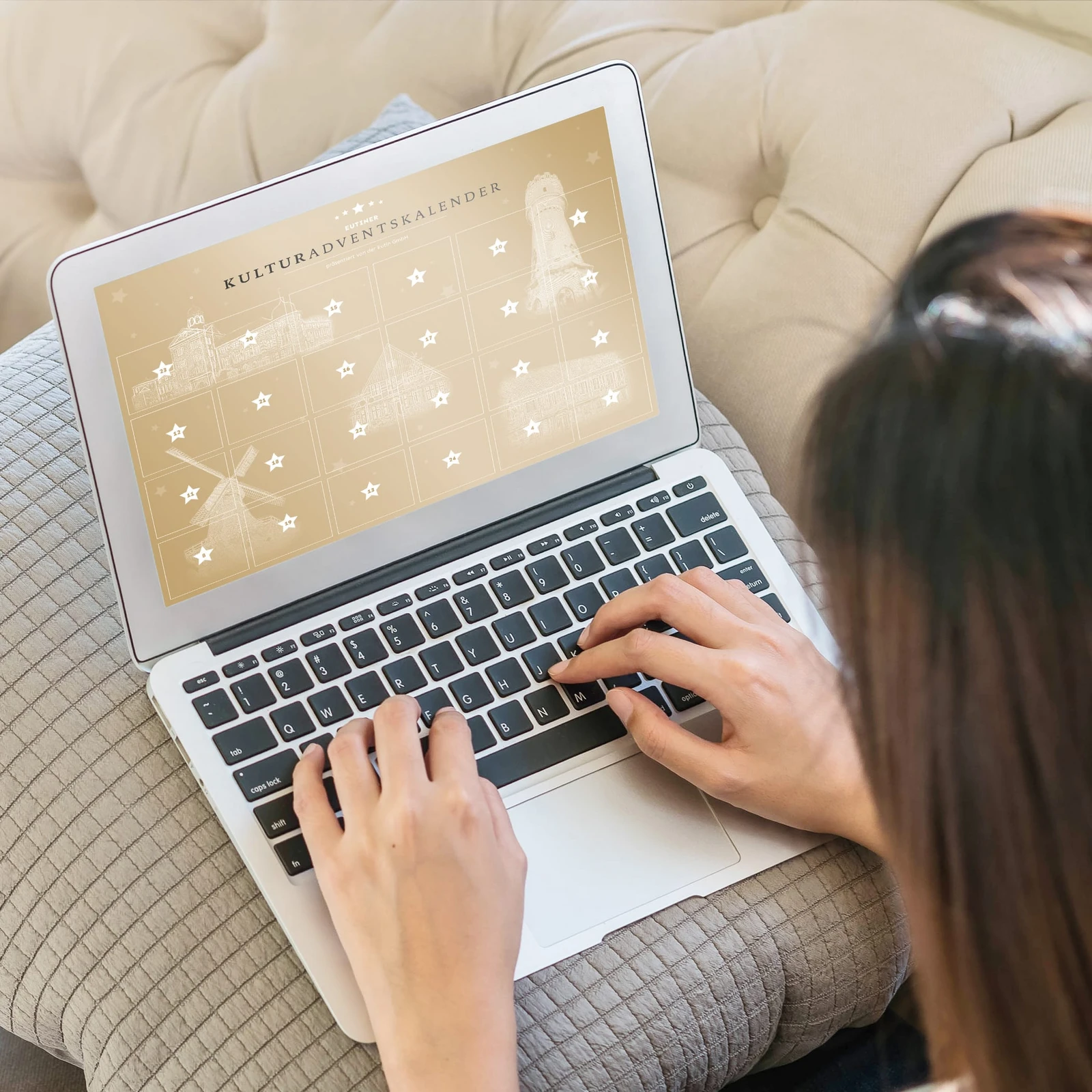 Person sitzt an Laptop, das einen Kulturadventskalender zeigt
