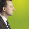 Seitenprofil eines Mannes im Anzug mit einem grünem Hintergrund