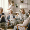 Eine Gruppe an älteren Menschen sitzen in einem Sofa und unterhalten sich